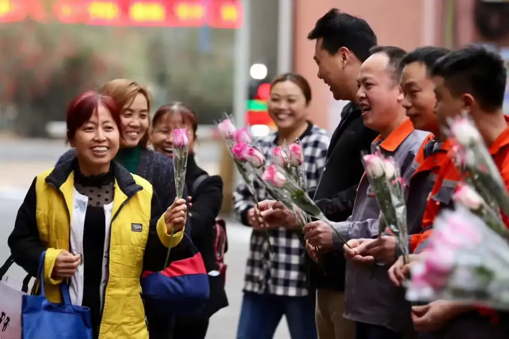 Male colleagues gifting roses to female staff at Gaia in Love, celebrating Women’s Day with vibrators for women in mind.