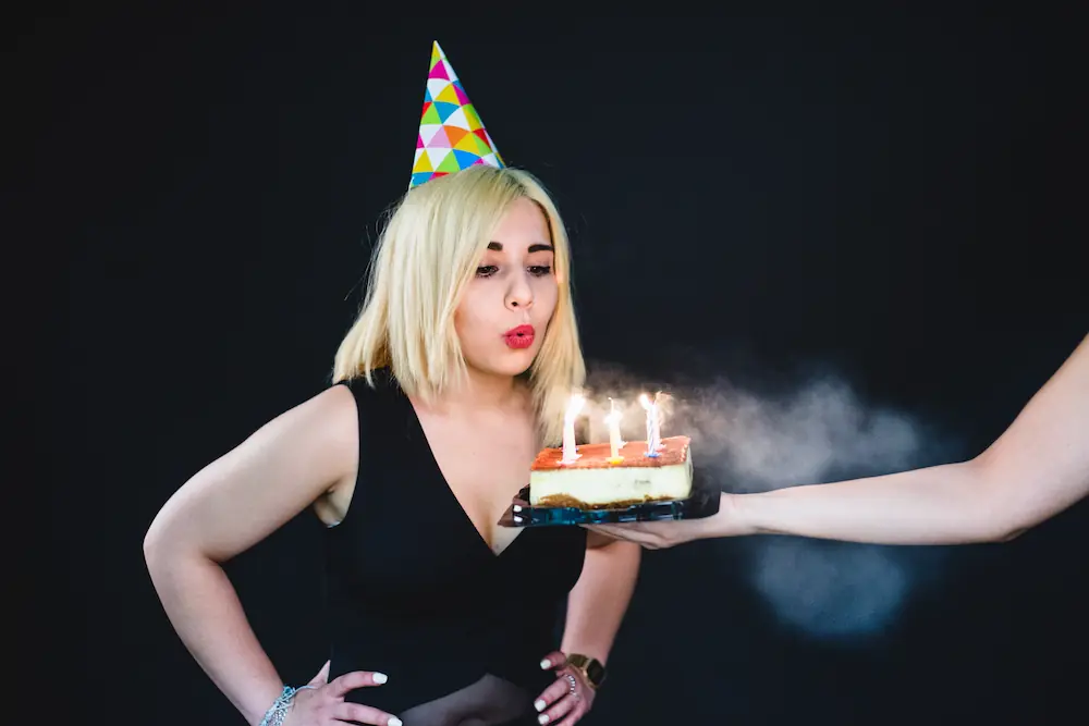 A joyful woman blowing out birthday candles during a Gaia in Love team celebration, showcasing unity and appreciation. Explore our collection of sex toys for women to enhance personal joy and connection.