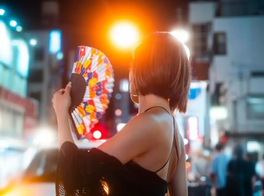 A confident young woman enjoying a vibrant city night, reflecting Gaia in Love’s innovative G-spot vibrators that empower women and enhance lifestyles.