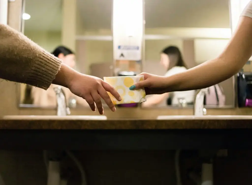 Hands exchanging a discreet package in a bathroom setting, symbolizing Gaia in Love’s commitment to privacy and customer care in logistics and supply chains.