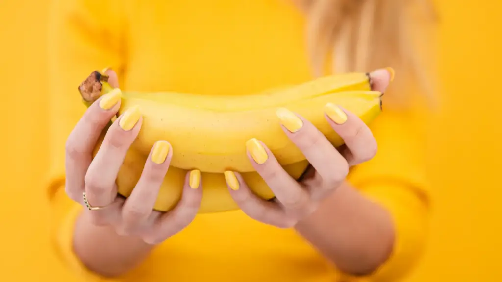 Close-up of a woman holding bananas with vibrant nails, highlighting Gaia in Love's creative and stylish approach to female vibrators.