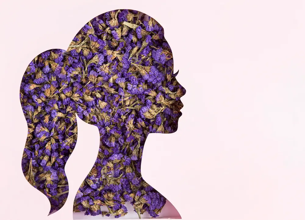 Silhouette of a woman's profile filled with purple flowers, symbolizing women empowerment, individuality, and natural beauty, aligned with Gaia in Love's vision.