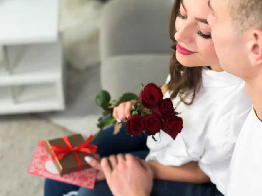 Couple celebrating Valentine’s Day with a gift, red roses, and a card. A thoughtful Valentine’s Day Gift from Gaia in Love.