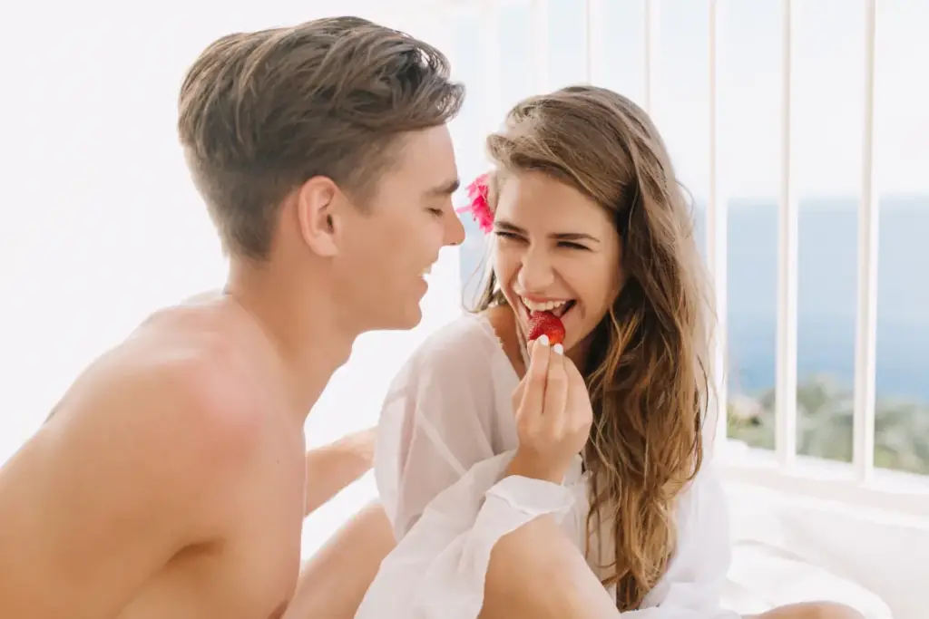 Couple enjoying a romantic moment together, sharing a strawberry on Valentine’s Day. Perfect for celebrating love with a Valentine’s Day Gift For Couples from Gaia in Love.