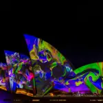 Sydney Opera House illuminated with vibrant lights, symbolizing Australia’s thriving market for couples toys and innovations by Gaia in Love.