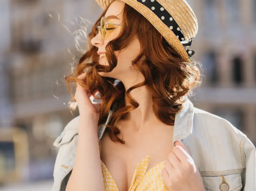 A cheerful woman with red hair in a stylish hat enjoying the outdoors. Perfect representation of confidence and empowerment, aligned with Gaia in Love's mission to support sellers of remote control vibraters on Amazon Japan.