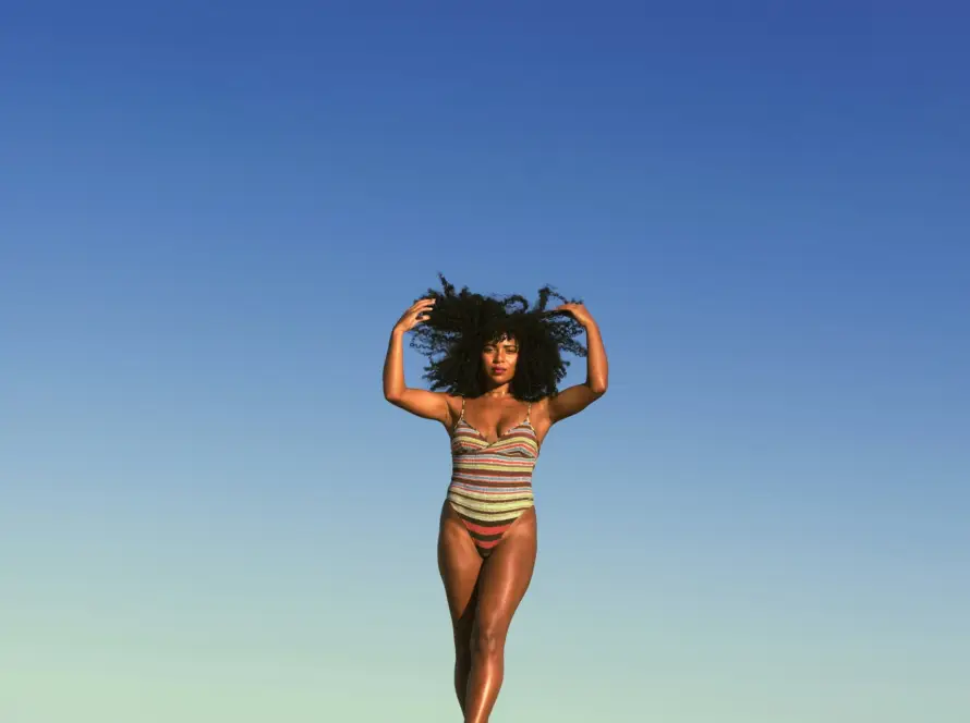 Confident woman standing under the blue sky, symbolizing empowerment and self-care. Explore Gaia in Love’s ladies sexy toy designed for pleasure and safety.