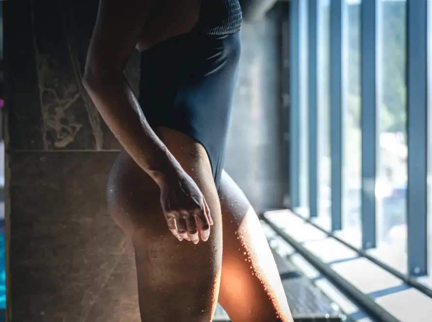 A young woman in a black swimsuit enjoys a moment of relaxation by the pool, embracing self-care and wellness. This peaceful scene represents the confidence and empowerment that Gaia in Love promotes, ideal for those who practice Kegel training for enhanced well-being and personal growth with our Kegel Training Vibrator.