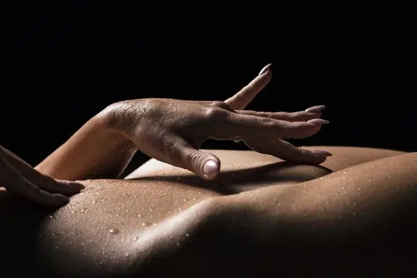 Sensual hand caressing skin, symbolizing the connection between physical touch and mental well-being, supported by Gaia in Love's insights.