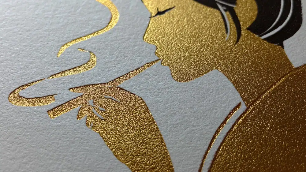 Close-up of premium packaging finish with gold foil stamping on textured paper.