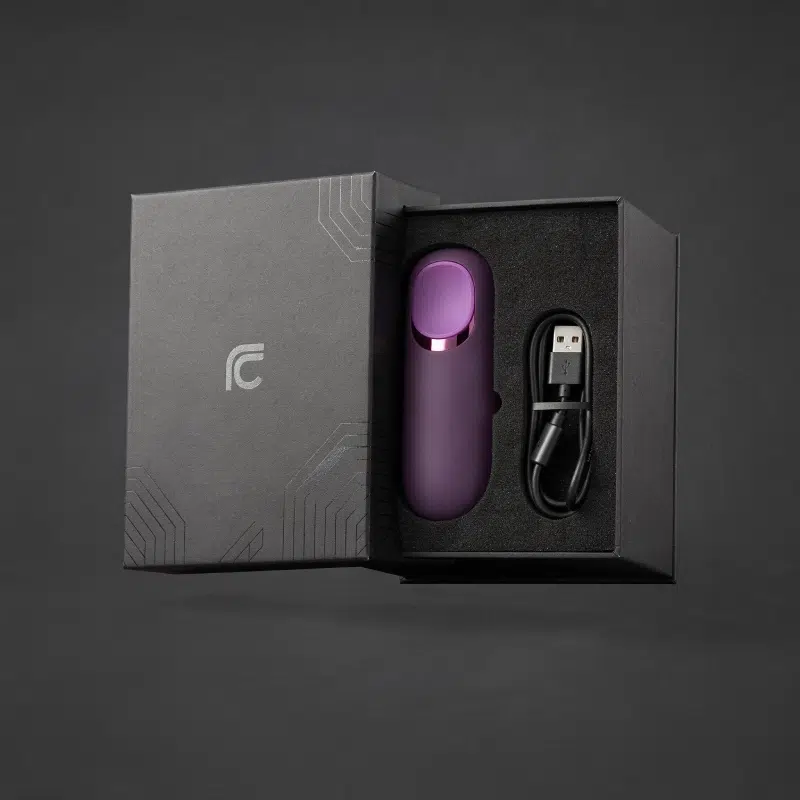 Premium rigid gift box sex toy packaging with foam insert holding a purple vibrator and USB charging cable.